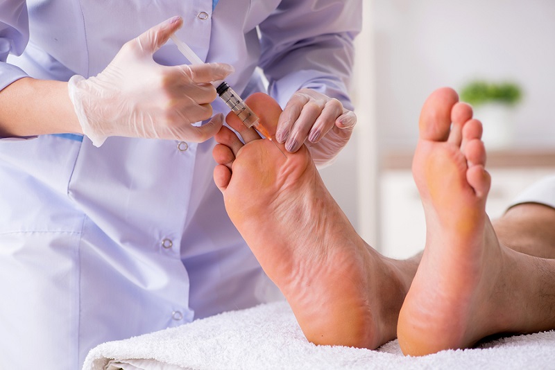 Podiatrist treating feet during procedure